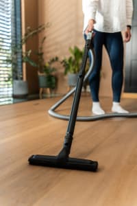 
                    Showing use of a Flexit standard floor nozzle with telescopic wand while vacuuming a wooden floor