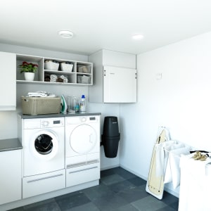 
                    Vaskerom med veggmontert Flexit Nordic S4 ventilasjonsaggregat over vask og tørketrommel