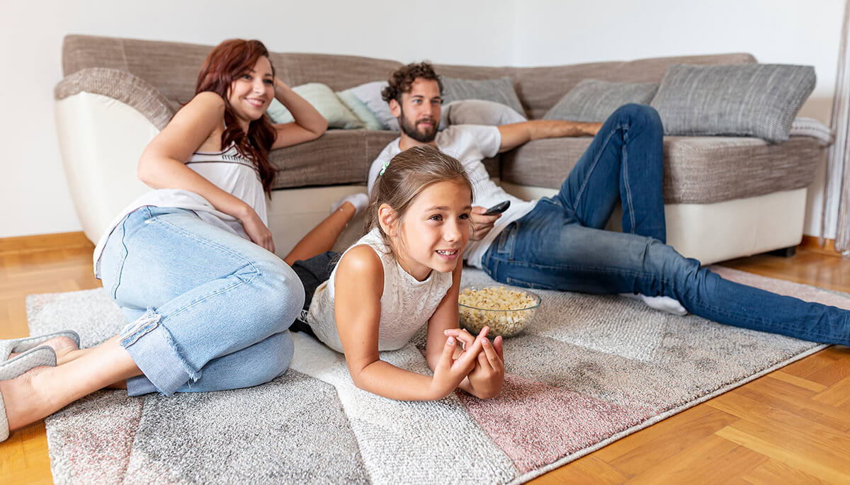 family-watching-tv-on-a-rug