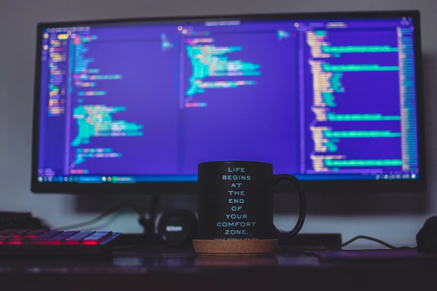 Cup with message in front of screen with code