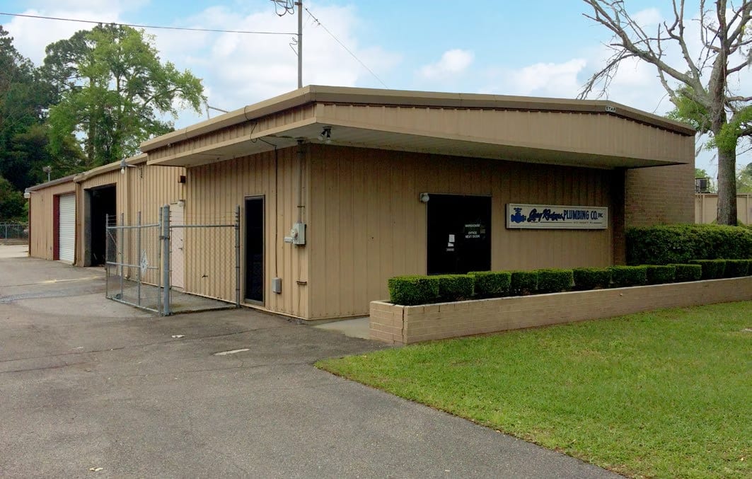 Single-storey warehouse building behind a fenced yard in Jacksonville