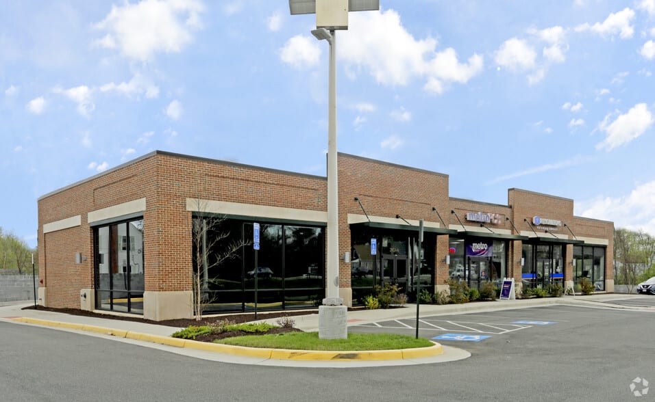 Brick retail strip on a street corner with parking in front