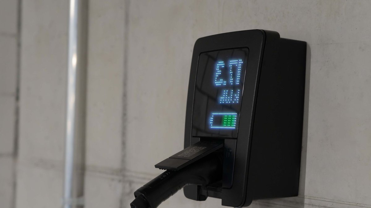 New Chevy Bolt charges more than twice faster Detailed view of an electric vehicle charging station indoors, showcasing charging technology.