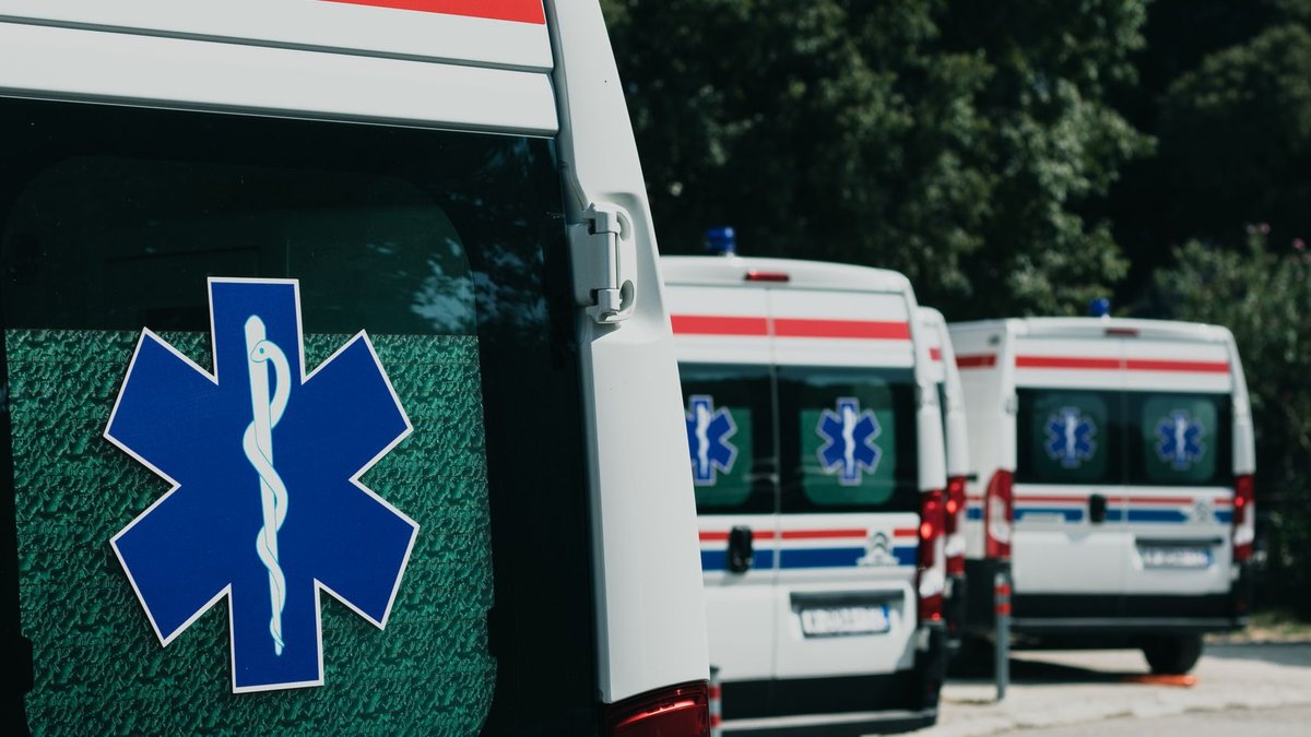 AI Billing Tools Spark Healthcare Cost Debate Three ambulances parked outdoors, ready for emergency healthcare situations.