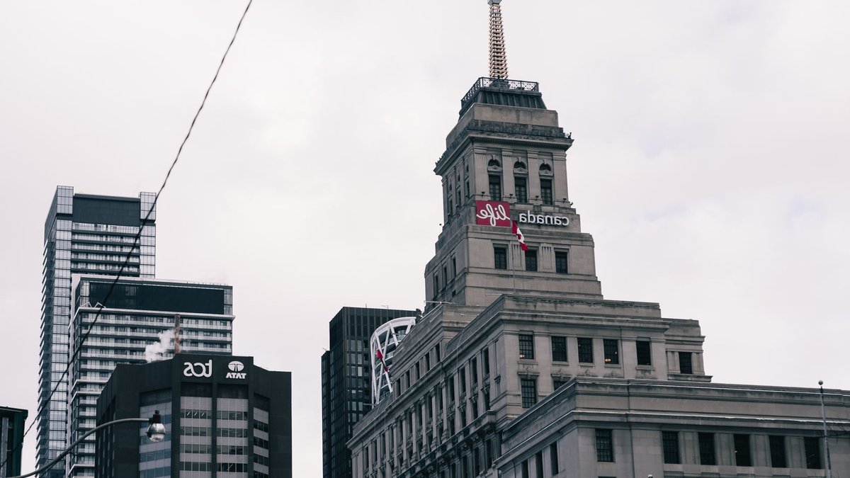 Canada’s banks still lag in money-laundering defenses A silhouetted person walks amid a row of buildings.