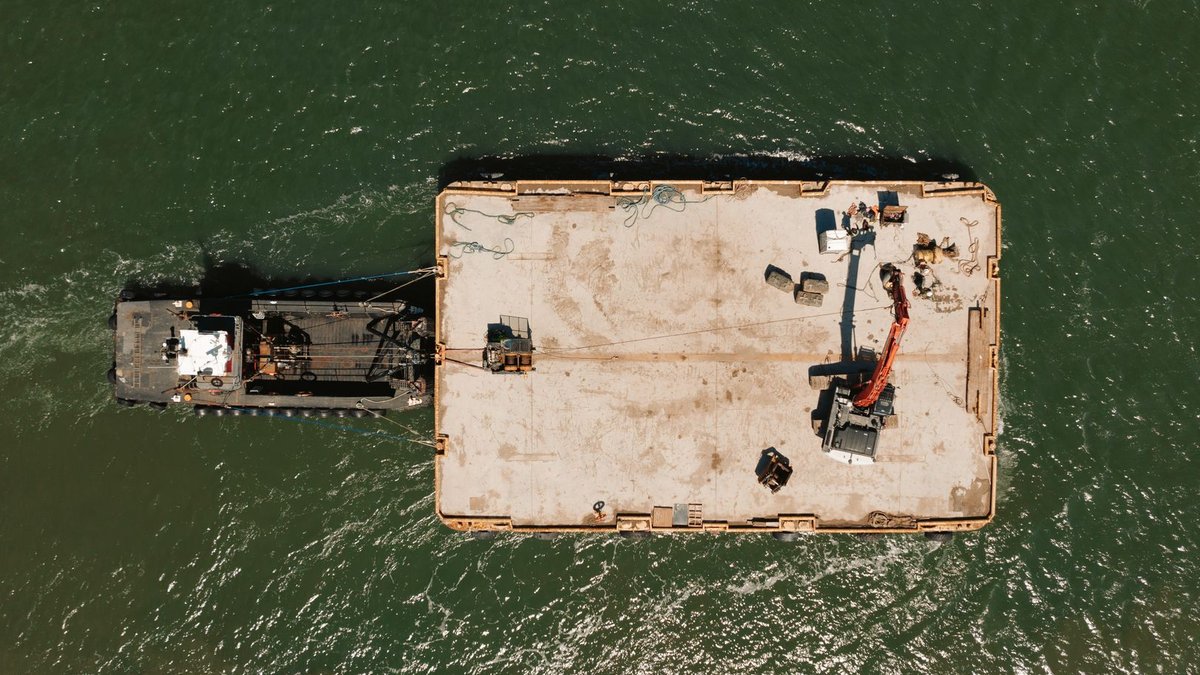 High angle photo of a construction platform on a water body, showcasing industrial activity.