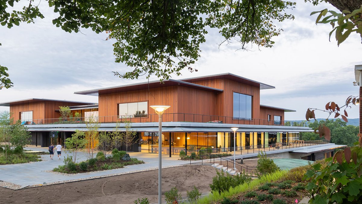 Herzog & de Meuron Plans Social Hub at Amherst College Modern two-story building at Amherst College with large windows and wood-paneled exterior, surrounded by landscaped greenery