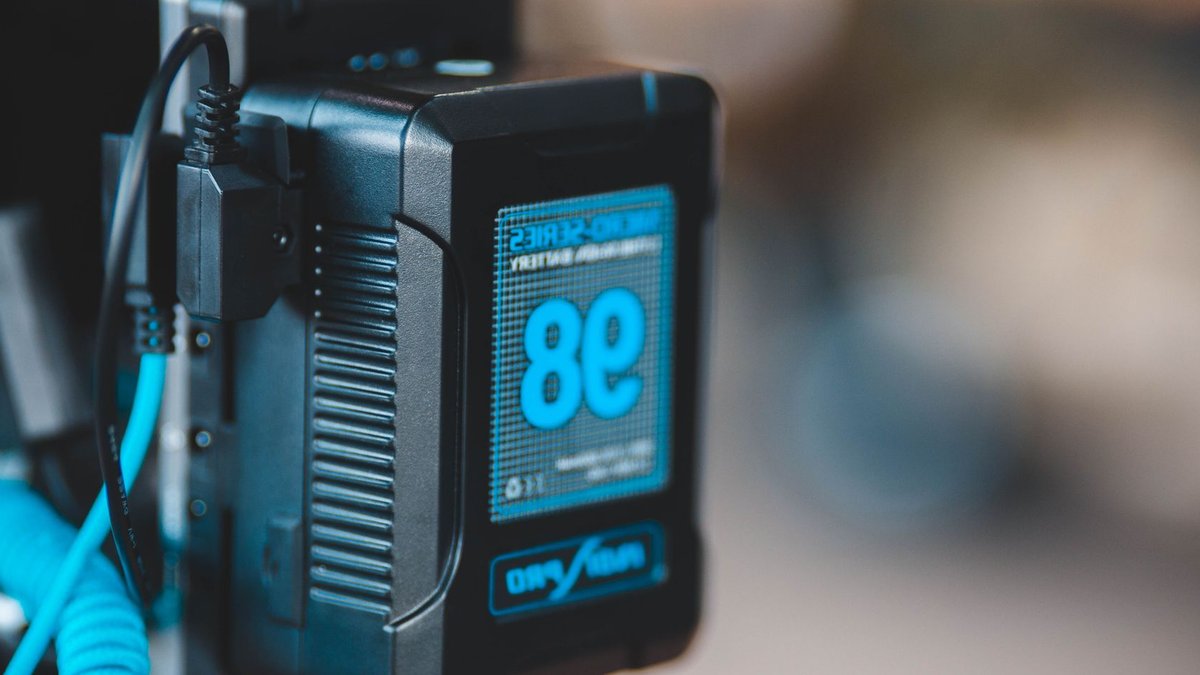 Close-up of a high-capacity portable battery with digital display showing 98 percent charge.