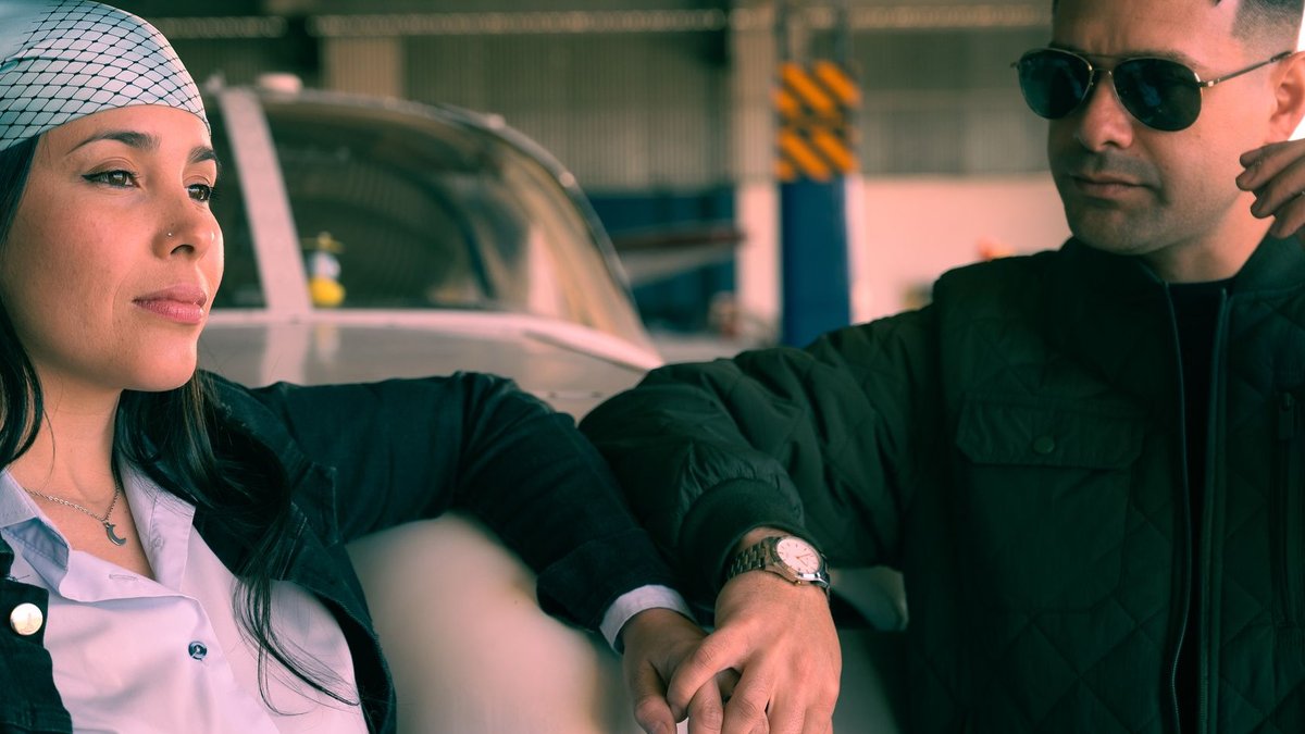 Fashionable individuals posing near an aircraft in a hangar, showcasing style and aviation themes.