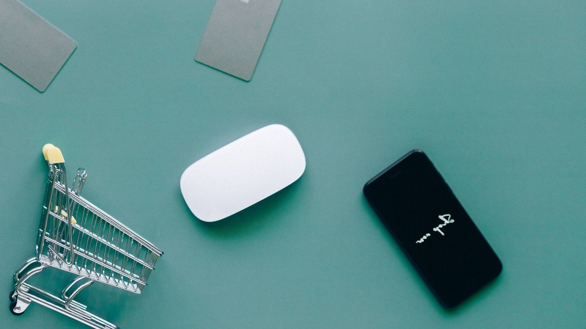 Firmly Launches No-Code Platform for Agentic Commerce Integration Flat lay of smartphone, cards, and shopping cart on green. Perfect for e-commerce and online shopping themes.