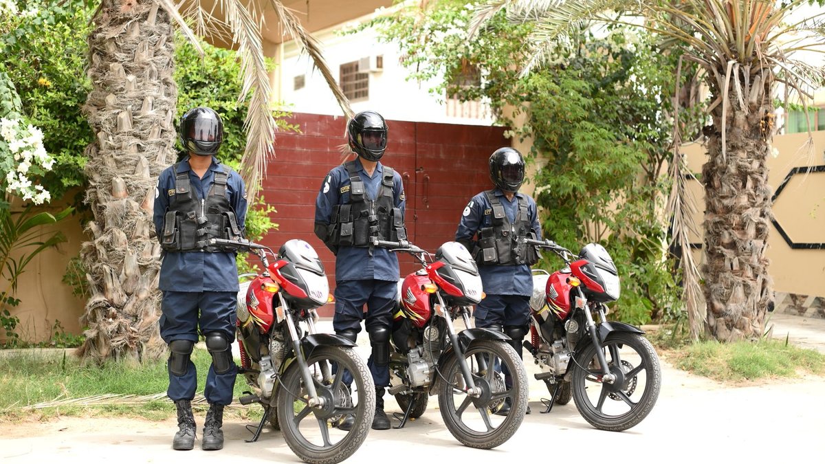 Governor Kuri Denies Rift Over Police Academy Three security guards in uniform standing by motorbikes outdoors in a tropical setting.