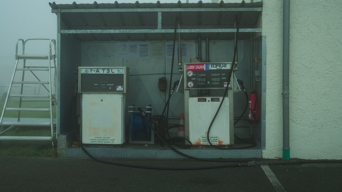 An outdoor fuel station with vintage pumps on a foggy day, featuring copyspace.
