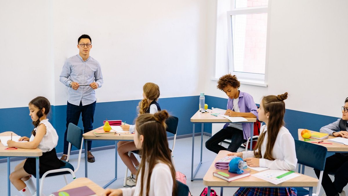 Chicago philanthropist honored for education and community impact Teacher instructing a diverse group of elementary students in a modern classroom setting.