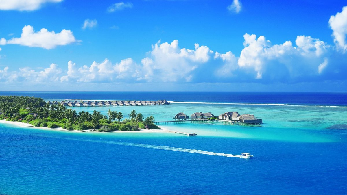 Bangladesh seeks currency swap with Maldives to ease remittances Crystal clear waters surround a luxurious Maldives resort under a bright blue sky.