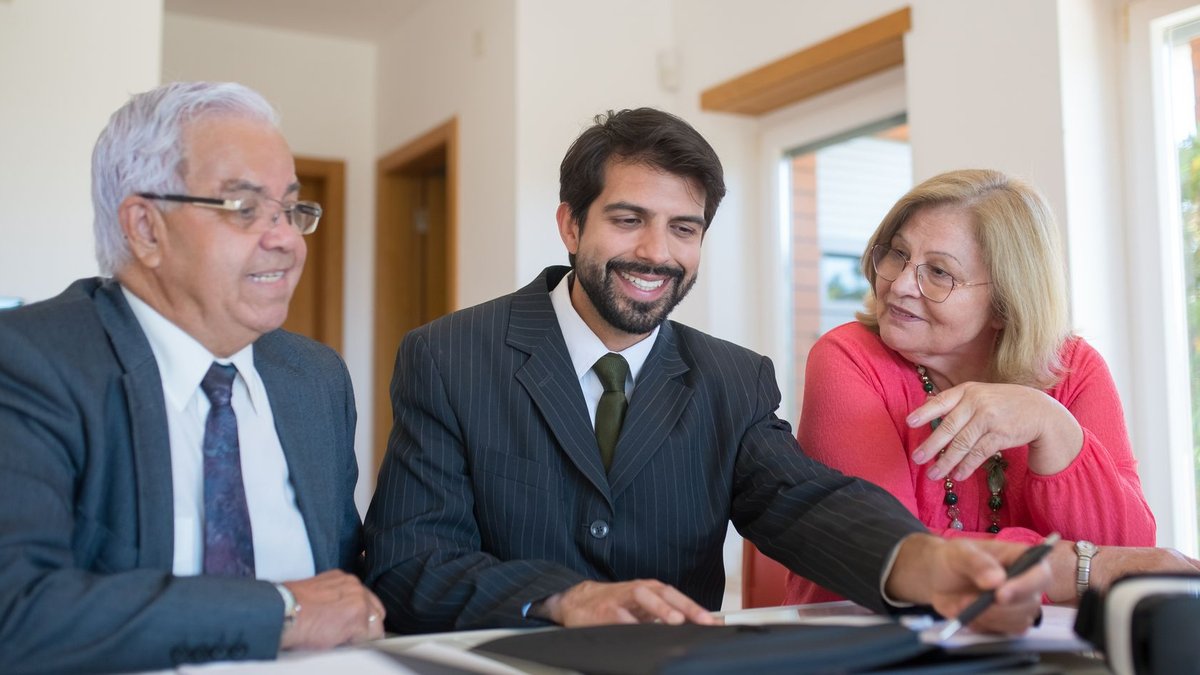 Indigenous Realtors Form National Association in Canada Professional realtor discussing real estate deal with senior couple in bright office setting.