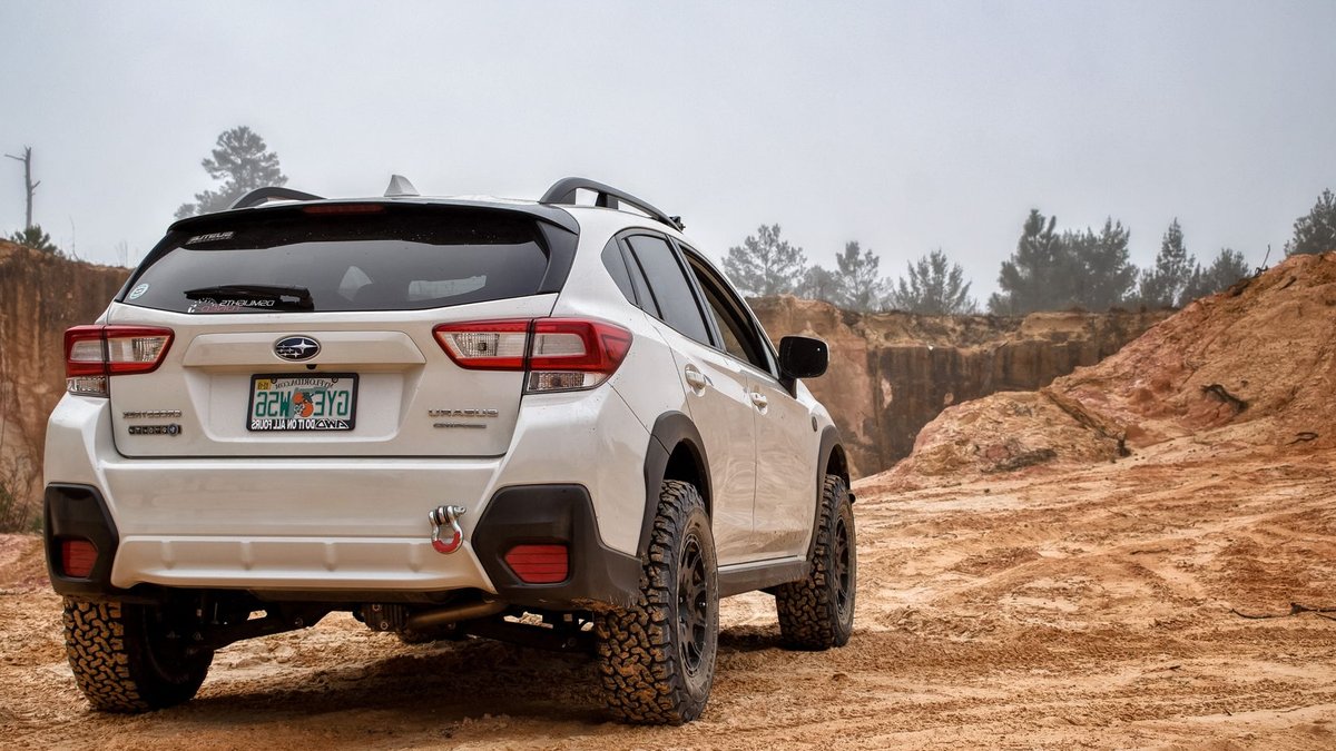 Rivian R2’s All-Terrain Tires Have a Strange On-Road Performance Benefit A rugged white SUV navigates a sandy desert terrain, showcasing its off-road capabilities.