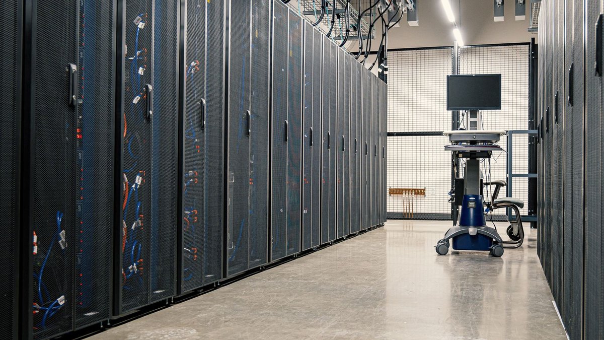 UK banks face hidden AI risks from lack of control Steel framework cabinets housing servers networking devices and cables in contemporary equipped data center.