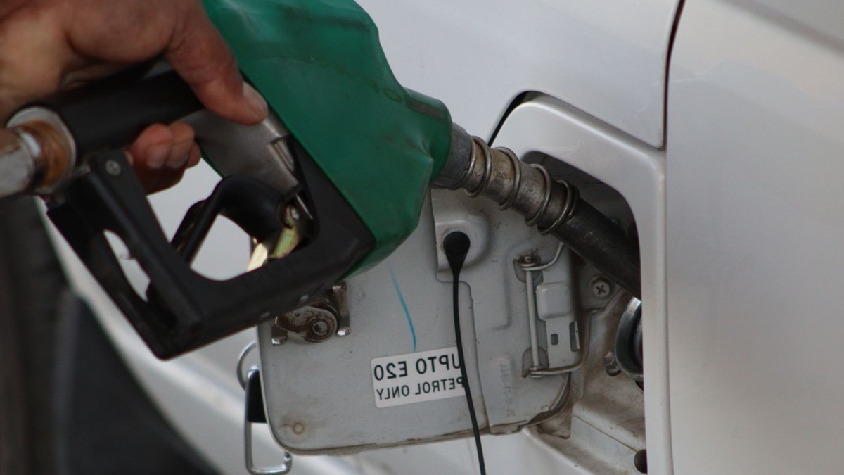 Clean-fuel industry pushes Delhi regulator for flexibility Close-up of a hand refueling a vehicle. E20 petrol pump nozzle in use.