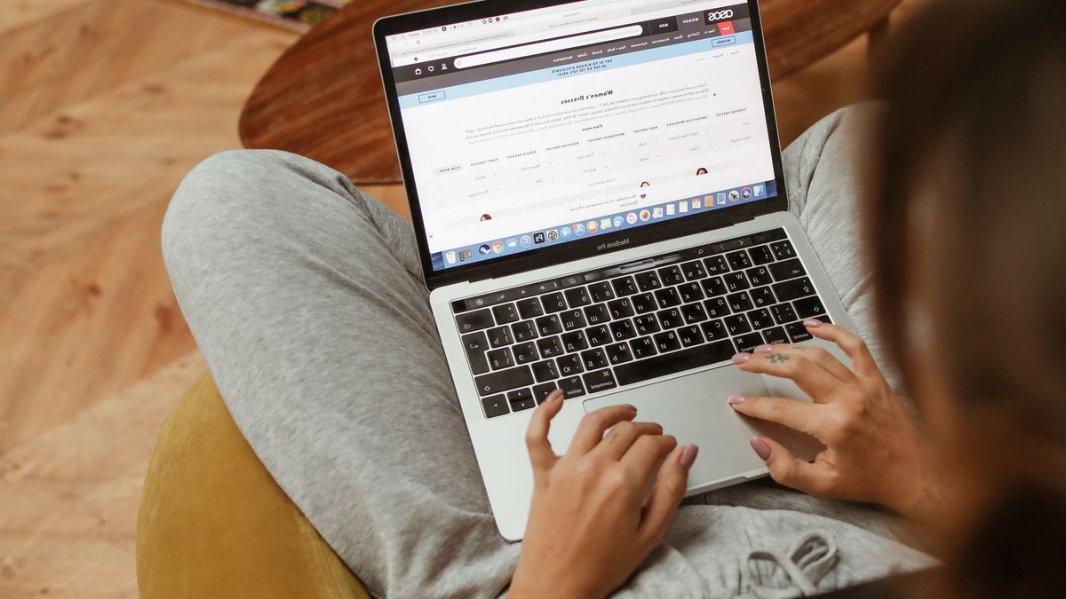 Ahold Delhaize websites to return online soon A woman relaxes with her laptop browsing online shopping websites from her cozy home.