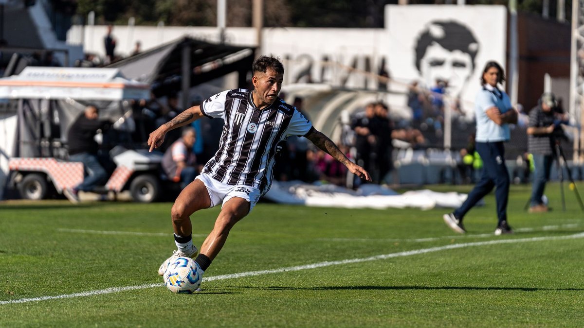 Forlán on Discipline and Patience in Sports and Trading Dynamic shot of a footballer in action on the field during a sunny day match with spectators.