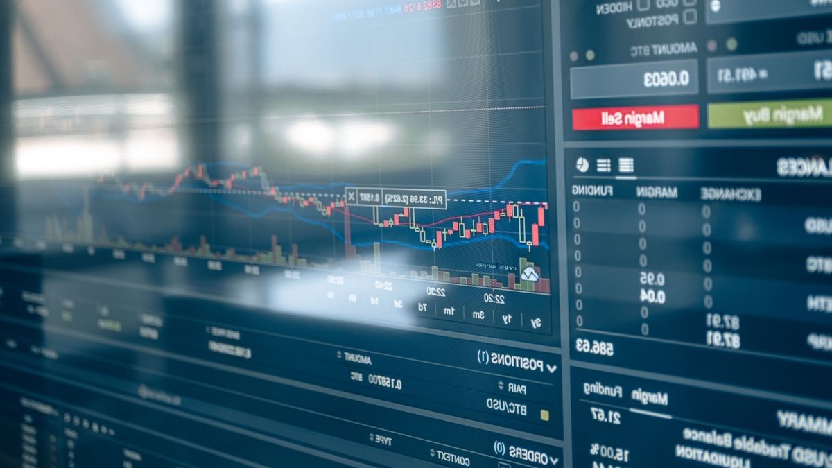 Close-up of a digital screen displaying stock trading graphs and cryptocurrency values. Ideal for finance and technology them