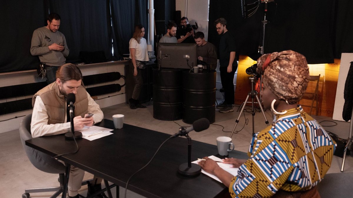 Diverse team in a studio setting recording a podcast with professional equipment.