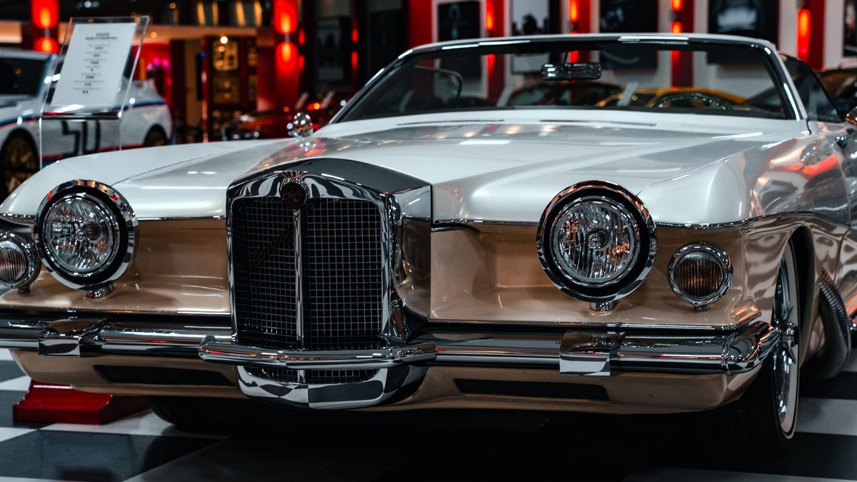 Close-up of a classic vintage car displayed in a chic indoor showroom.