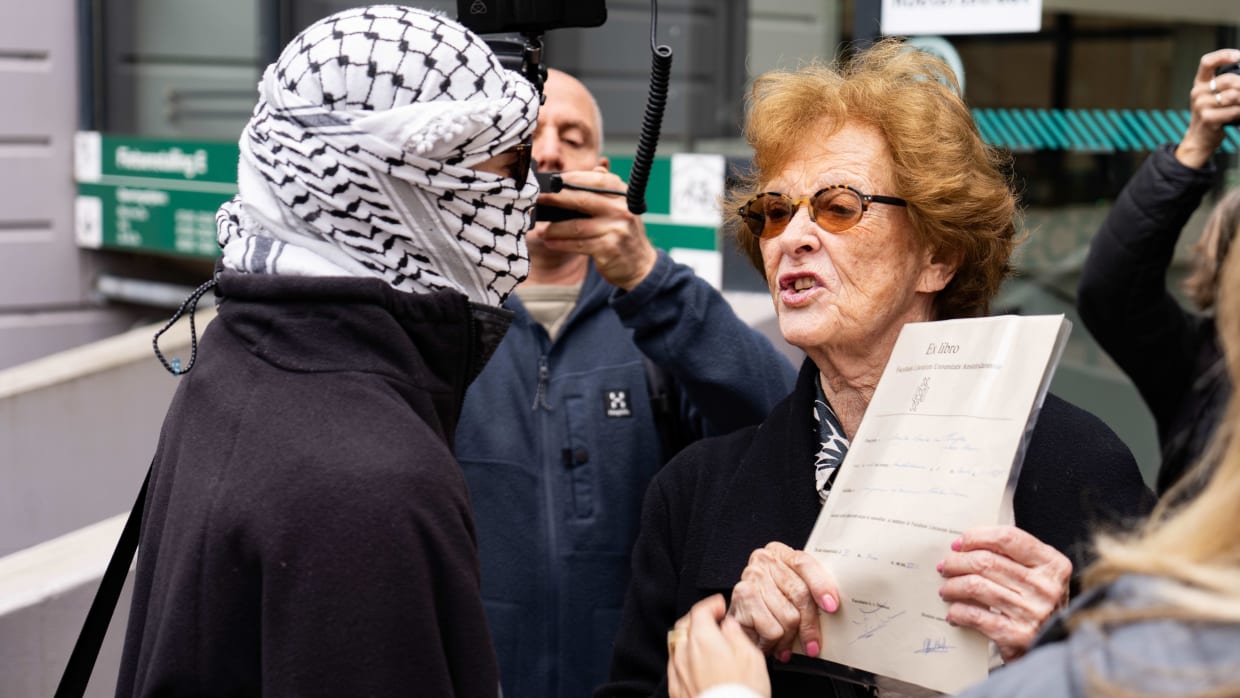 Een UvA-alumnus met haar bul in debat een pro-Palestijnse demonstrant