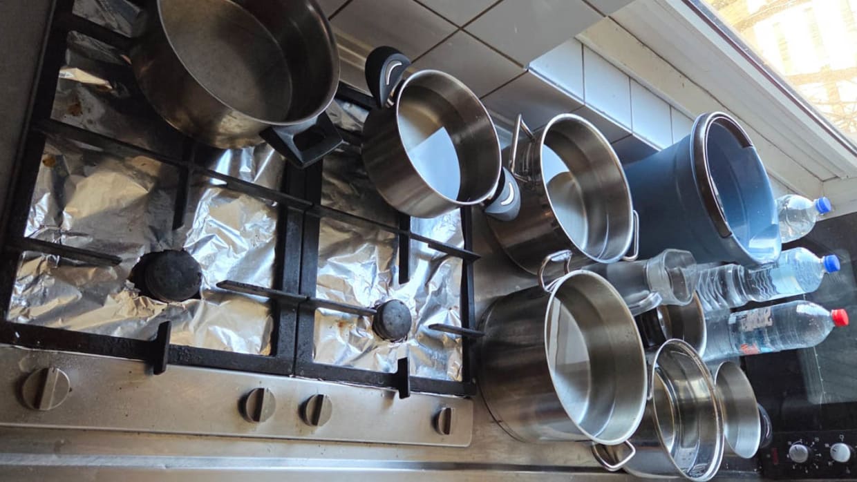 Studenten verzamelen pannen vol water wanneer het stromend water het begeeft