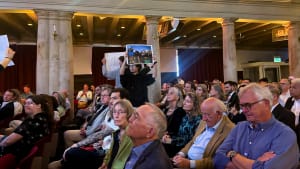 Protesters hold up signs