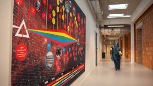 Het wanddoek met de tijdlijn van de moderne natuurkunde op de Plantage Muidergracht en de Roeterseilandcampus.