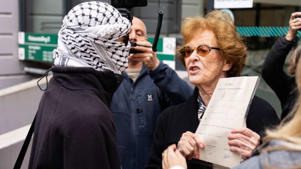 Een UvA-alumnus met haar bul in debat een pro-Palestijnse demonstrant