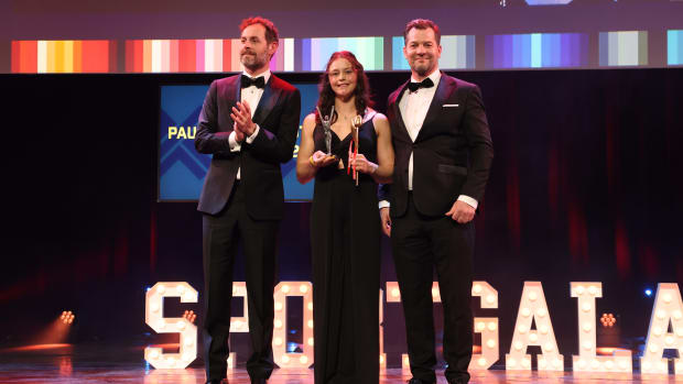 Elze Gerts ontvangt de prijs van echtgenoot van Paulien van Deutekom Kay van der Kooi (links) en broer Roland van Deutekom (rechts).