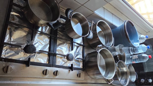 Studenten verzamelen pannen vol water wanneer het stromend water het begeeft