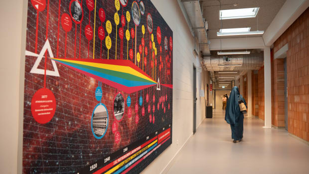 Het wanddoek met de tijdlijn van de moderne natuurkunde op de Plantage Muidergracht en de Roeterseilandcampus.