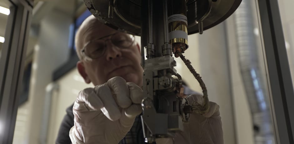 Hans Ellermeijer buigt zich over een temperatuursensor van de Photo Emissie Spectrometer Famos.