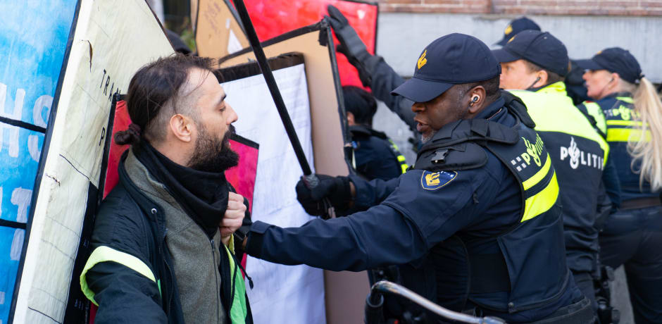 Politie en demonstranten met elkaar in gevecht.