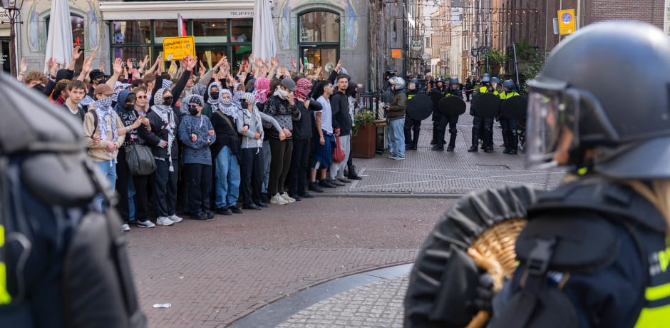 De politie drijft de demonstranten terug.