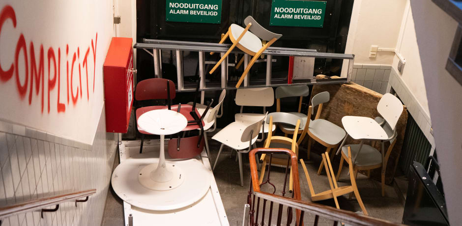 Een deel van de schade aan het Maagdenhuis: de muren zijn beklad met graffiti en stoelen worden gebruikt als barricades.