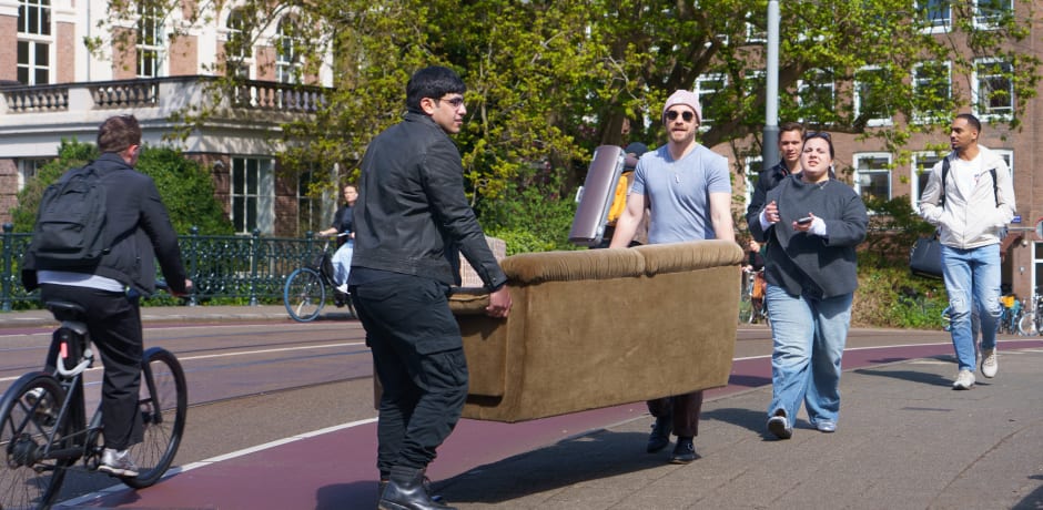 Verderop in de Roetersstraat, tegenover het Dr. Sarphatihuis, worden de benodigdheden voor een tweede woonkamer klaargezet.