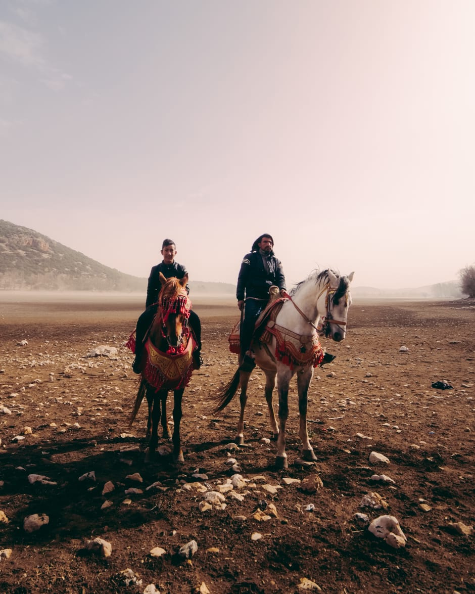 Berbers te paard op de droge bodem van wat ooit een levendig meer was in Ifrane, Marokko