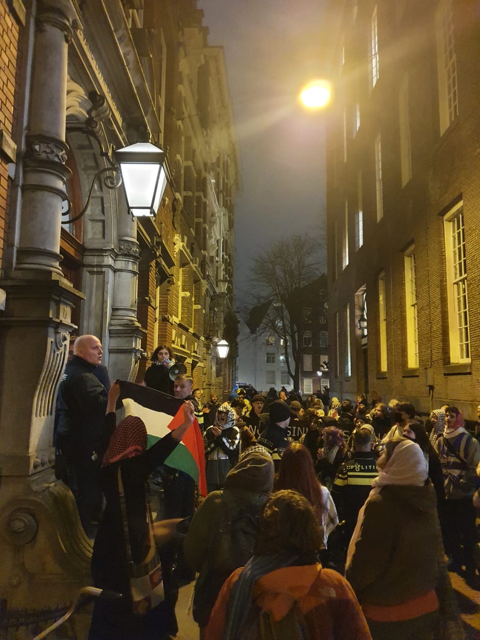 Buiten in de Handboogstraat wachtten demonstranten de aanwezigen bij de dies natalis op, om leuzen naar hen te scanderen.