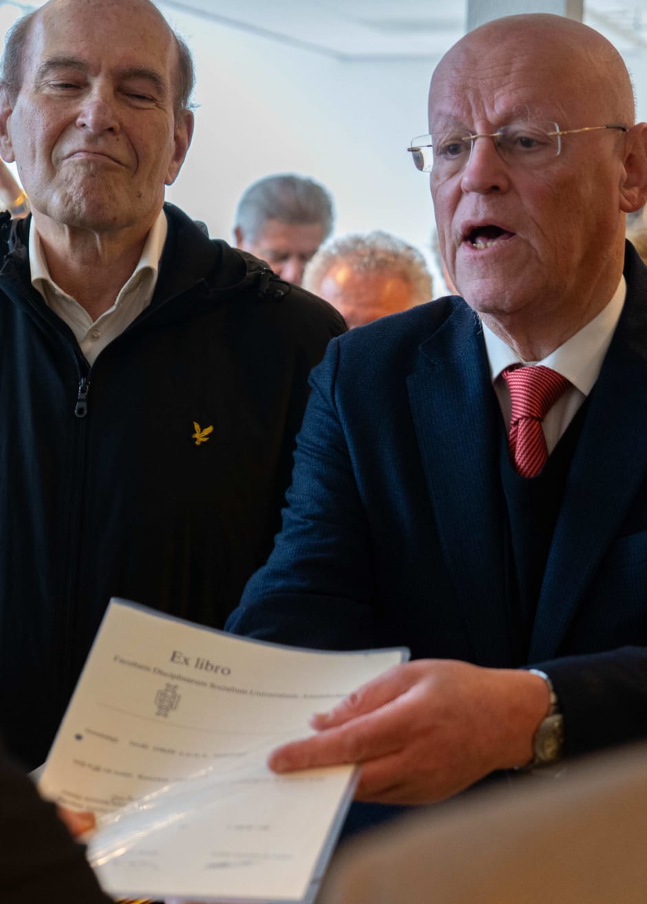 Ronny Naftaniel en Uri Rosenthal leveren hun diploma in bij collegevoorzitter Edith Hooge.