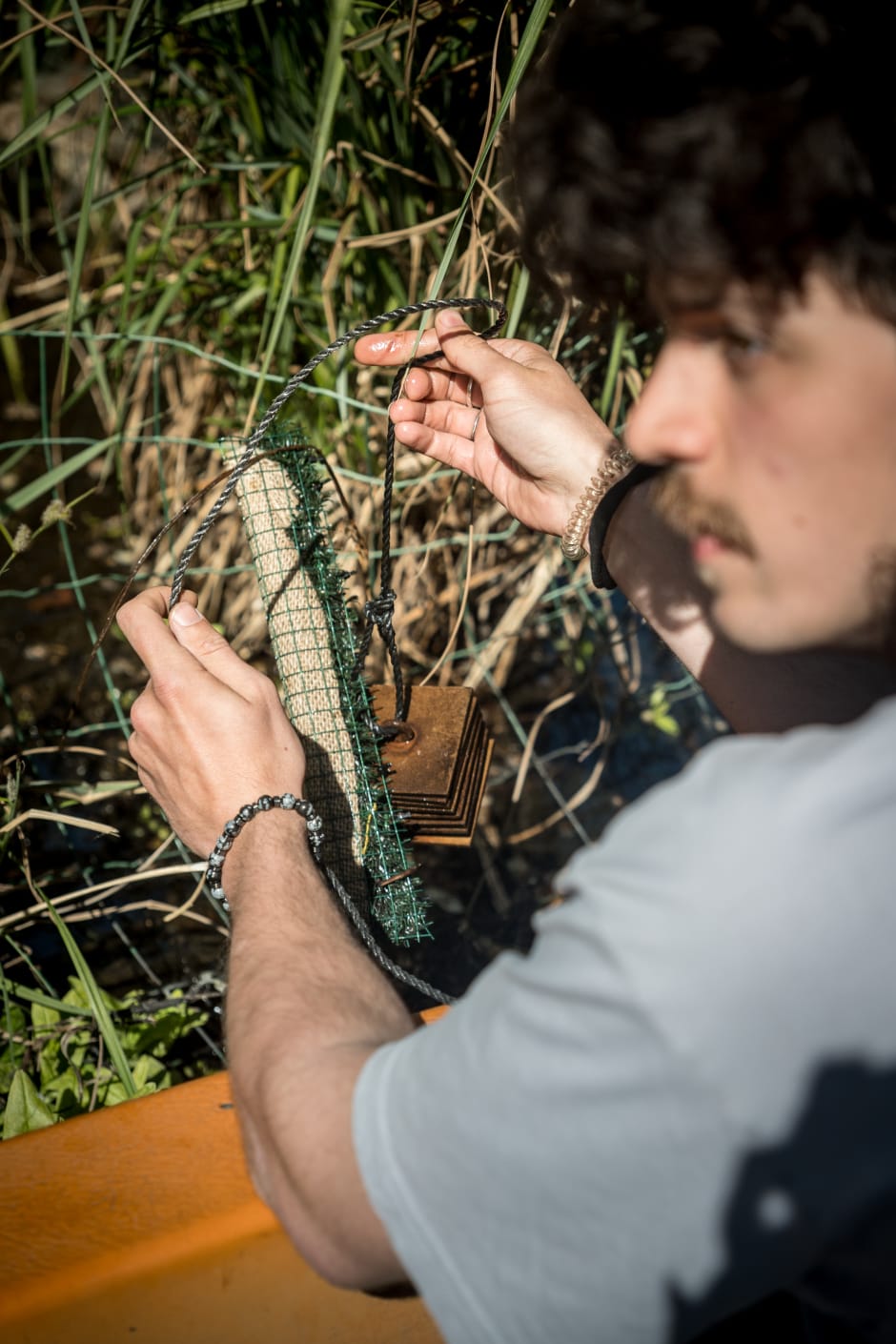 Masterstudent Tol (26) brengt een een onderwaterinsectenhotel aan in een watertuintje.