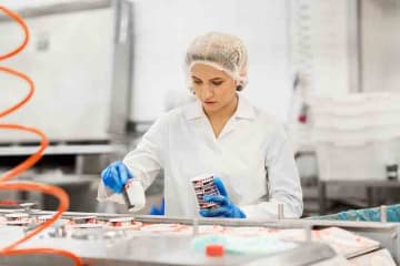 woman working at ice cream factory conveyor