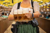 A woman holding Oktoberfest etched beer mugs