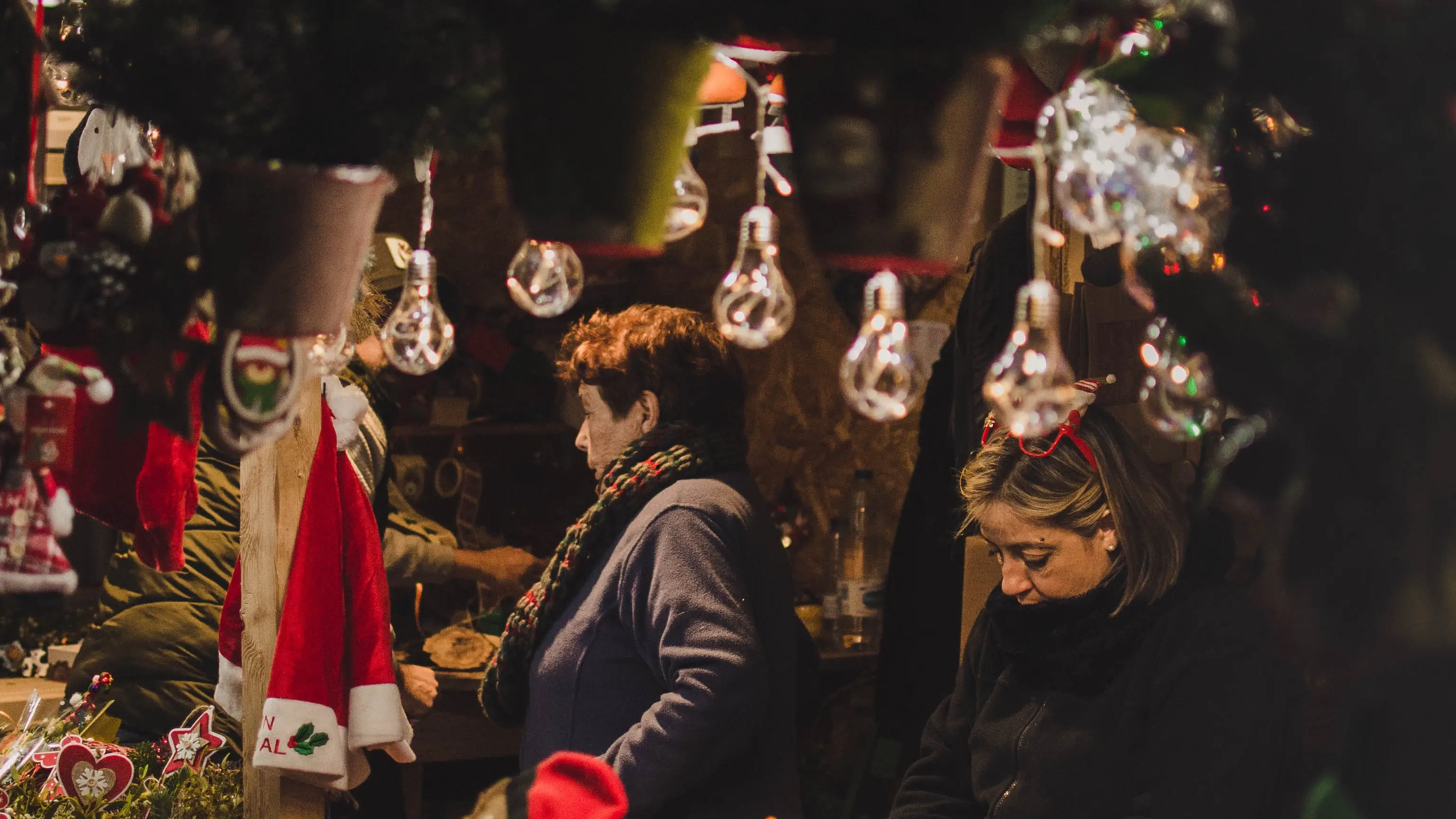 A woman selling ornaments at a Christmas market in Europe.