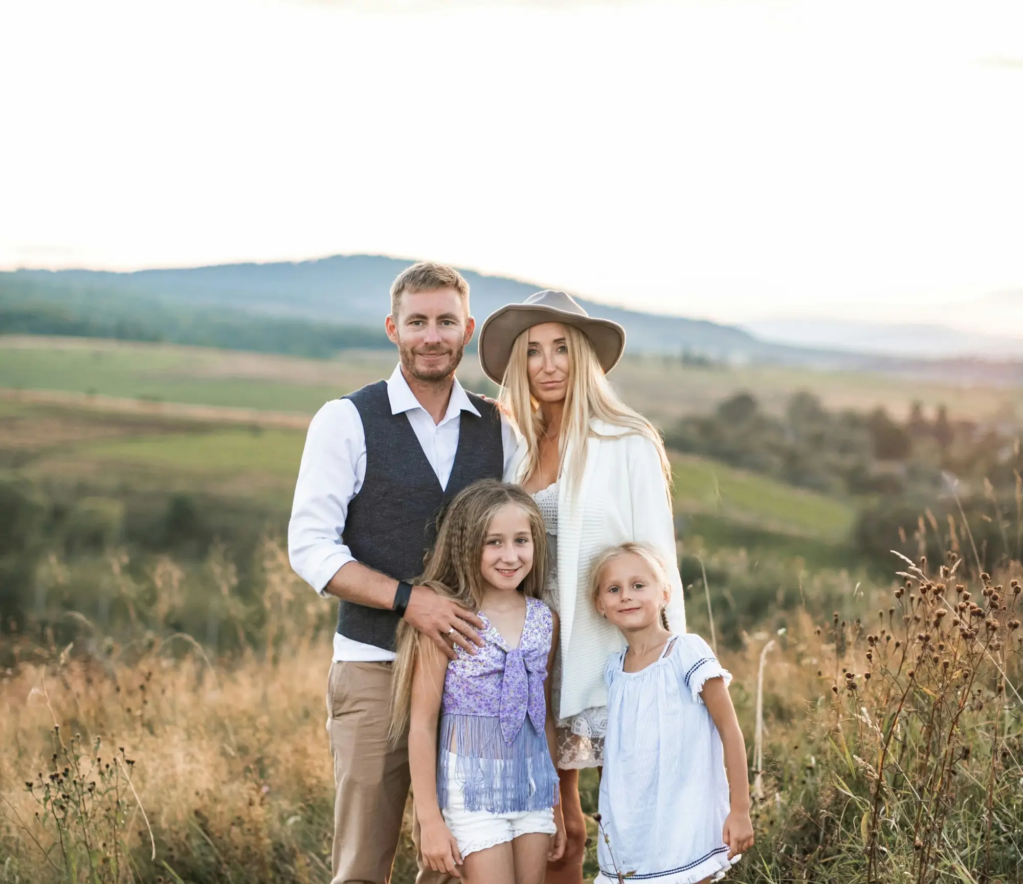 Three individuals standing in a field posing for a photo.