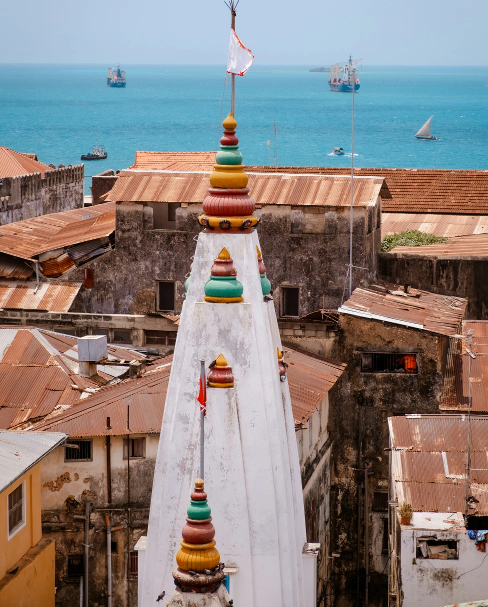 A row of quaint and vibrant houses by a body of water on a sunny day.
