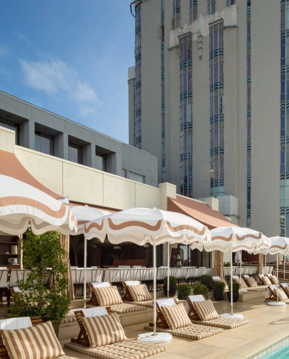 rooftop pool surrounded by striped loungers and umbrellas